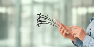 Hand mit Smartphone aus der symbolisch Noten herauskommen für Musik